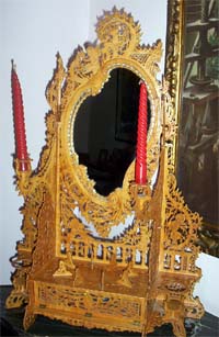 Italian dresser mirror made in fretworked wood with red candles on each side